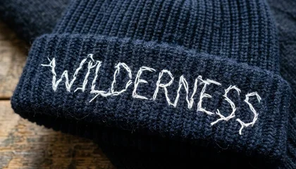 Knit beanie cap showing fabric loops visible through embroidery stitches without knockdown underlay
